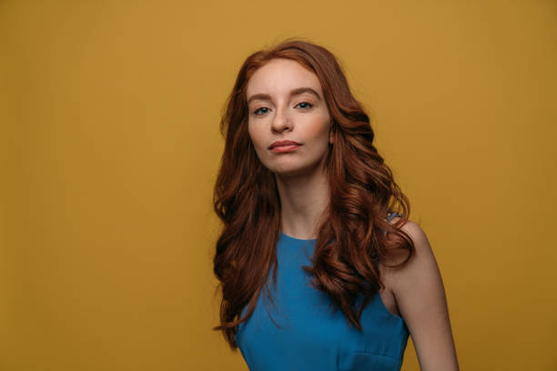 istock Beautiful redhead girl on yellow background. 1132350077