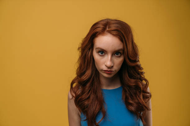 istock Beautiful redhead girl on yellow background. 1132350135