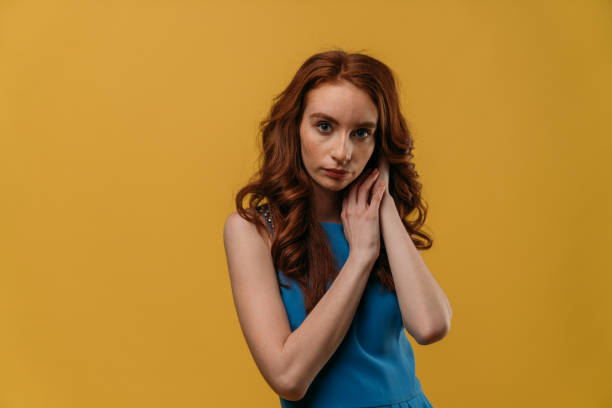 istock Beautiful redhead girl on yellow background. 1132350146