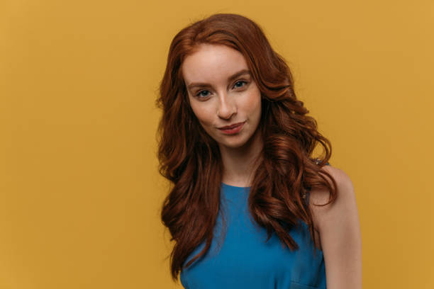 istock Beautiful redhead girl on yellow background. 1132350208