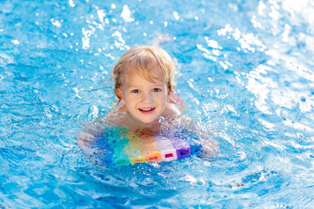 istock Child learning to swim. Kids in swimming pool. 1132351991