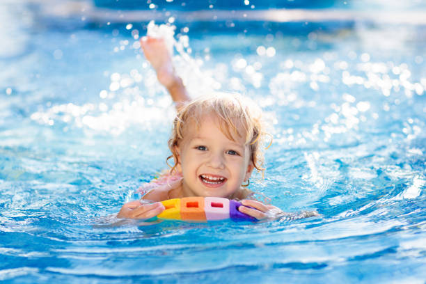 子供が泳ぐことを学ぶ。プール内の子供たち。 - float around ストックフォトと画像