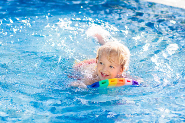 istock Child learning to swim. Kids in swimming pool. 1132355192