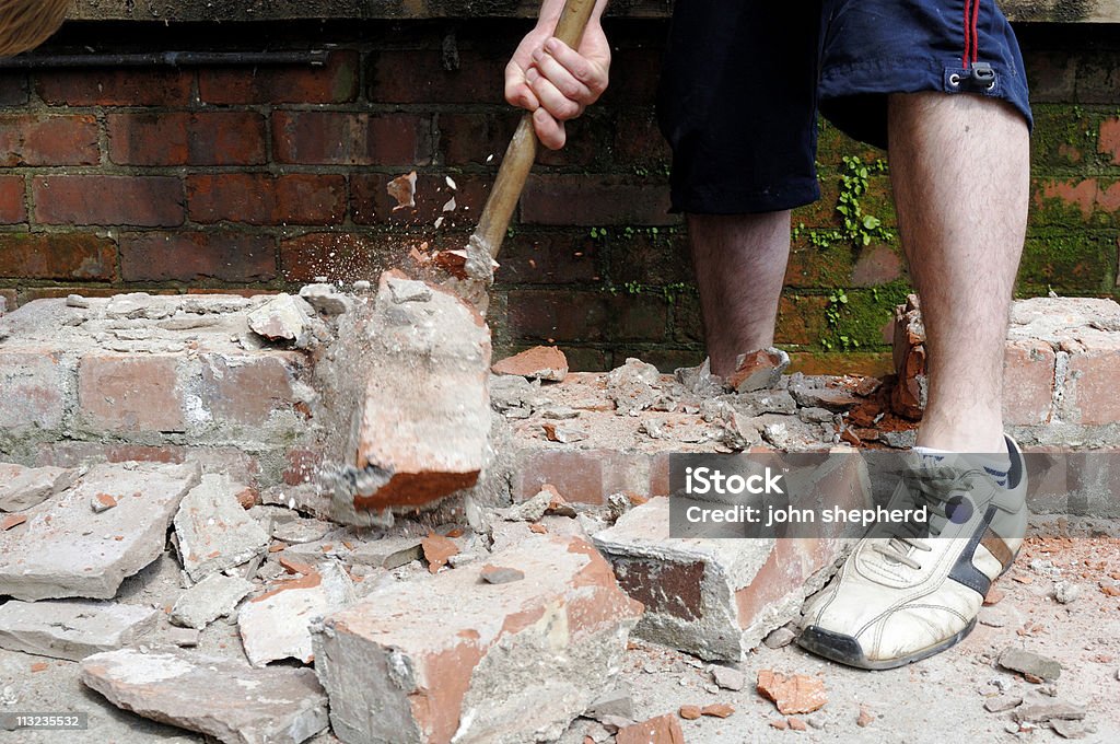 Slitta martello Bussare down muro di mattoni - Foto stock royalty-free di Muro