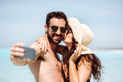 couple take a selfie on the beach in summer