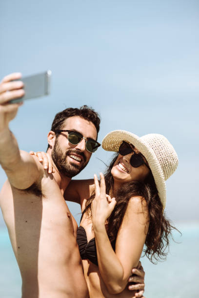 istock couple take a selfie on the beach in summer 1132357783