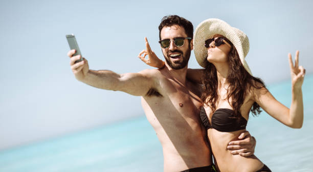 istock couple take a selfie on the beach in summer 1132357832