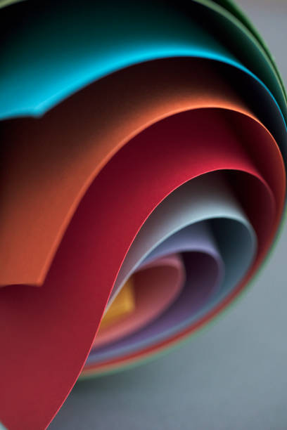 istock Curled corners of multi colored papers on gray background. 1132359275