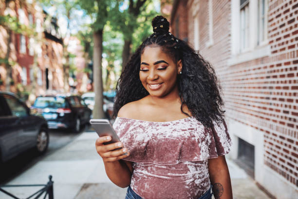 porträt der generation z nicht-kaukasische frau in den vereinigten staaten, mit telefon für die kommunikation - non urban scene fotos stock-fotos und bilder