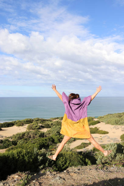 istock Woman in poncho happy jumping 1132365689