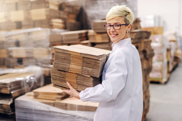 istock Smiling beautiful blonde woman relocating disassemble boxes in warehouse. 1132367814