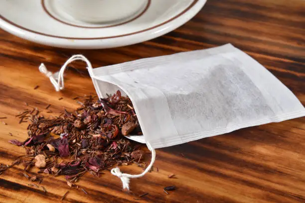A single use disposable tea filter bag with strawberry, Kiwi infused rooibos tea