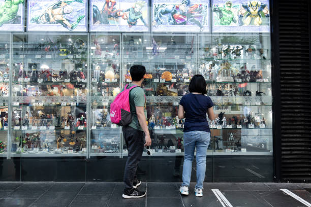 Window shoppers Sydney, Australia - February 7, 2019: Two people looking at figurines in front of the shop. action figure stock pictures, royalty-free photos & images