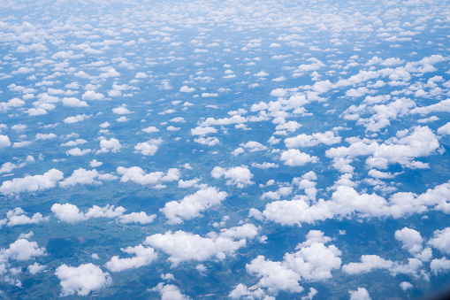 Sky scape cloudscape from aerial airplane shot of blue clouds. View flying above mountain from windows over Loei, Thailand.