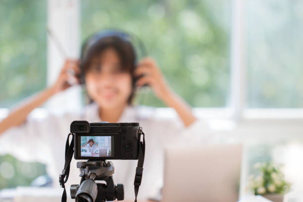 Happy Asian videoblog or student woman beauty blogger / vlogger recording tutorial coach presentation pass video for teaching live homework sharing online channel social media by mirrorless camera stock photo