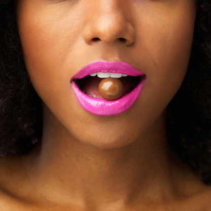 Shot of an unrecognizable woman posing with a chocolate ball in her mouth
