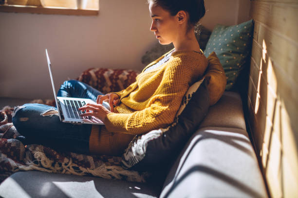 istock Young Woman Using Laptop at Comfortable Sunny Home 1132392860
