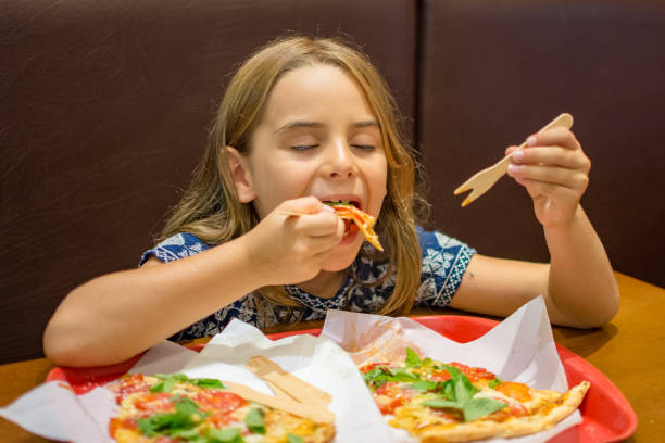 istock Child girl eating pizza 1132392904