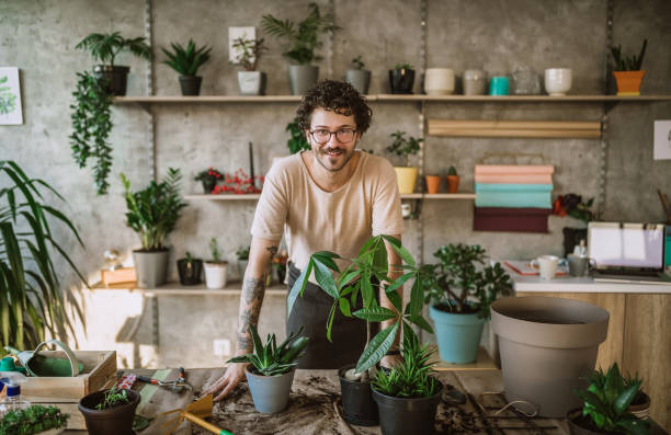 uomo fioraio allegro - fioraio negoziante foto e immagini stock