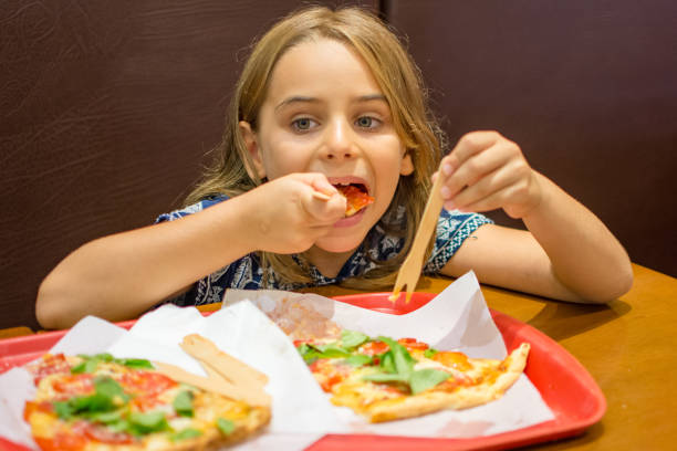 istock Child girl eating pizza 1132393034