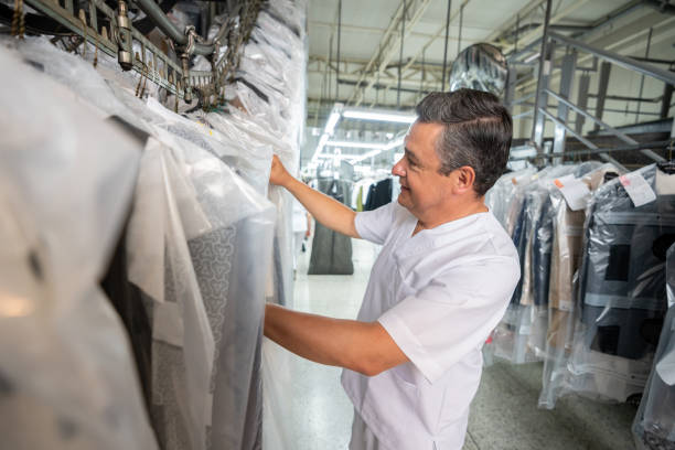 istock Mature man at a laundry service looking for a dry cleaned garment on conveyor belt smilign 1132394782