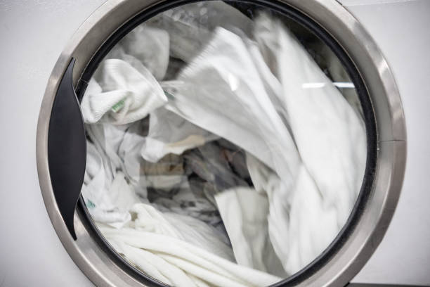 Close up of industrial washing machine at a laundromat Close up of industrial washing machine at a laundromat - No people bed sheets stock pictures, royalty-free photos & images