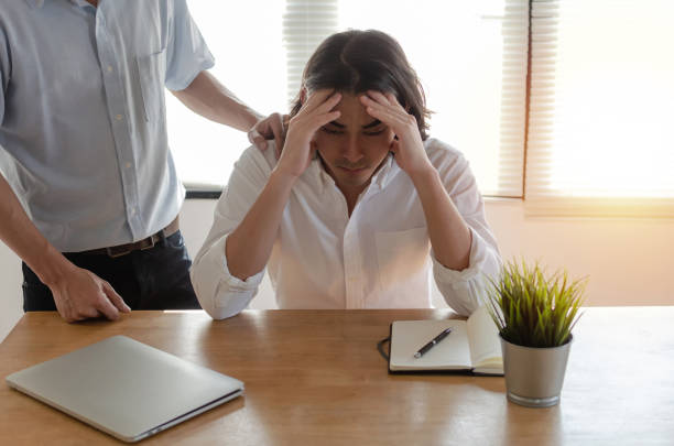 istock young asian business man upset about life problems with encourage support from his best friend and sitting in home office, fired from job,encouragement, unemployment, financial and investment concept 1132399071