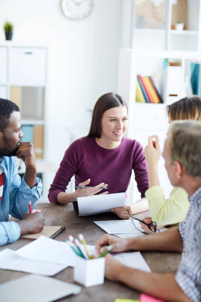 istock Excited multi-ethnic business colleagues sitting at table in office and discussing strategy at meeting 1132400396