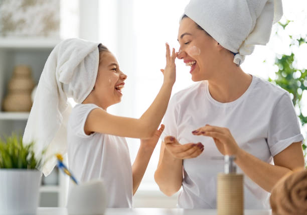 mutter und tochter pflegen die haut - mirror mother bathroom daughter stock-fotos und bilder