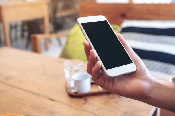 istock a hand holding white mobile phone with blank screen 1132403226