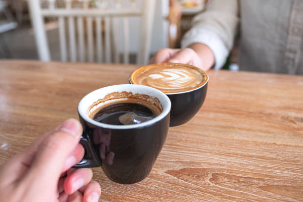 istock a man and a woman clinking two coffee mugs 1132403244