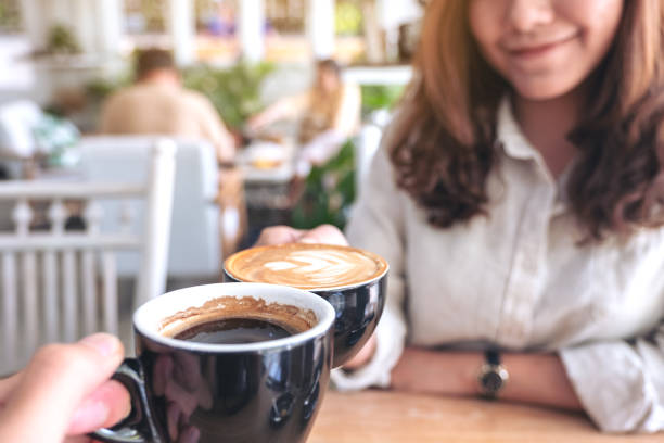 istock a man and a woman clinking two coffee mugs 1132403293