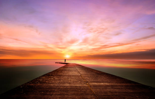 istock A person on a pier observes and contemplates a splendid sunset 1132404892