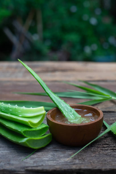 Fresh aloe vera stem and gel on wooden table, skin therapy concept, copy space stock photo