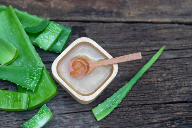 Fresh aloe vera stem and gel on wooden table, skin therapy concept, copy space stock photo