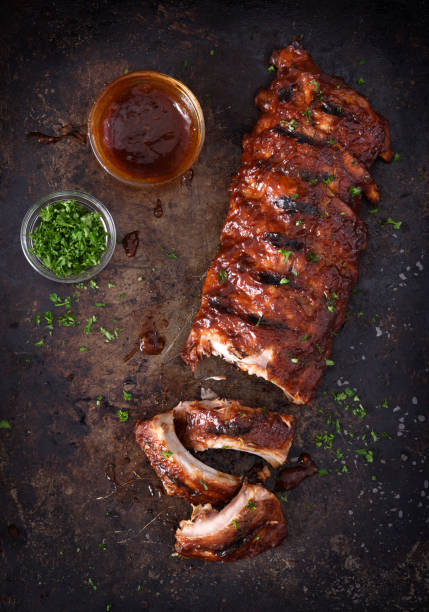Grilled barbecue pork ribs Full rack of grilled barbecue ribs with barbecue sauce on a dark background char grilled photos stock pictures, royalty-free photos & images