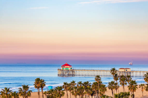 Huntington Beach Pier at sunrise. Sunrise sky over Huntington Beach Pier and the Pacific Ocean in Huntington Beach, California. huntington beach california stock pictures, royalty-free photos & images