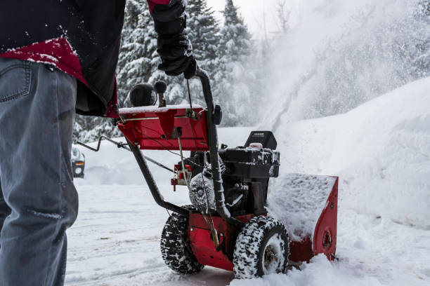 Senior Man Using SnowBlower After a Snowstorm stock photo