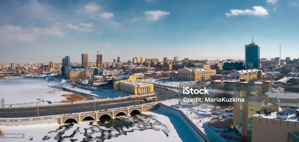 drone panoramic view of Chelyabinsk snow cityscape Aerial drone panorama; beautiful view Chelyabinsk city with white snowy streets and bridges; sunny winter day in South Ural capital; industrial and pollution problem; undeveloped urban environment Above Stock Photo