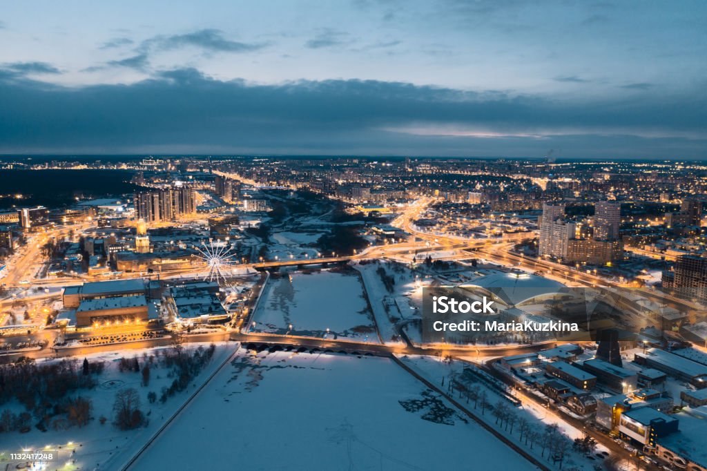 drone panoramic view of Chelyabinsk snow cityscape Aerial drone panorama; beautiful view Chelyabinsk city with illuminated streets and bridges at night; winter evening South Ural capital; industrial and pollution problem; undeveloped urban environment Above Stock Photo