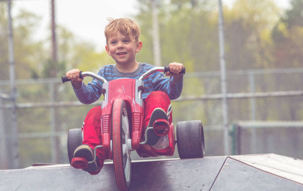 istock A Young Boy Playing Happily While Riding a Big Wheel Tricycle 1132418214