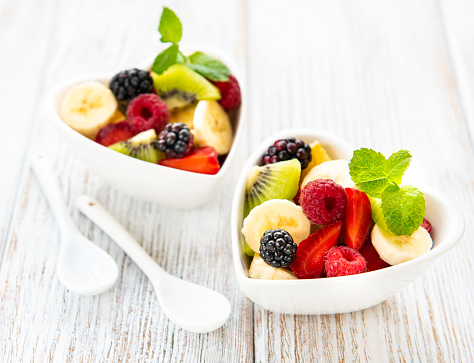 Bowls with fruits salad on a old wooden table