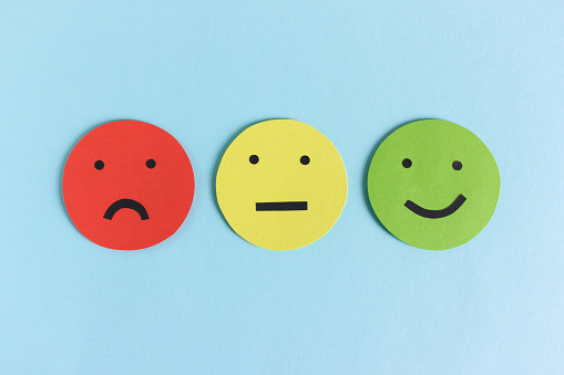 Row of three colorful smileys for expressing satisfaction, dissatisfaction and indifference composed on blue background
