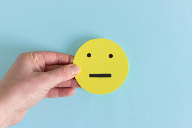 istock Crop hand with yellow indifferent smiley 1132428200