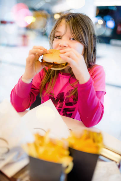 istock Beautiful child eating in a fast food 1132430413