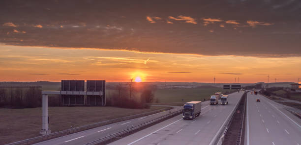 istock trucks on the highway at sunset 1132434687