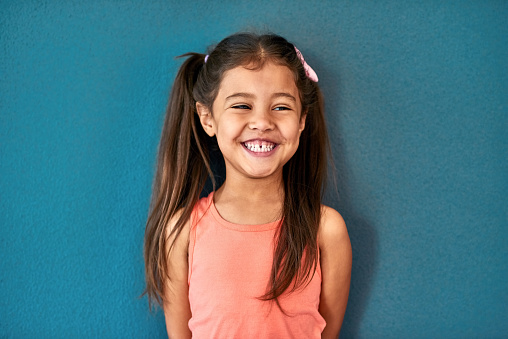 Studio shot of an adorable little girl posing against a blue background