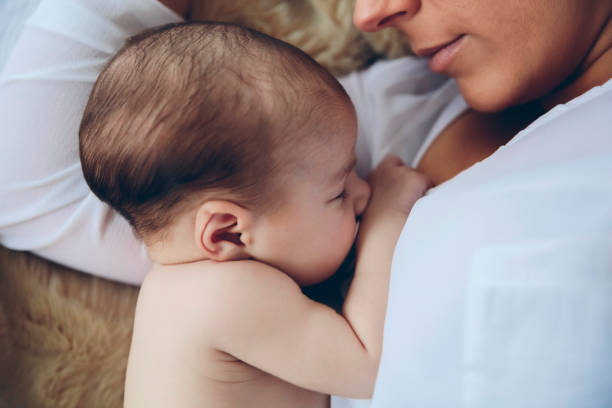 istock Newborn lying on the bed embraced by her mother 1132437329
