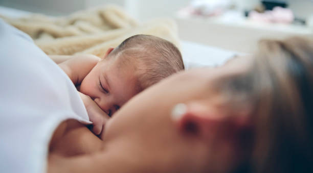 istock Newborn lying on the bed with her mother 1132437330