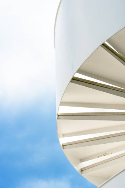 istock White spiral staircase against the sky. 1132439647